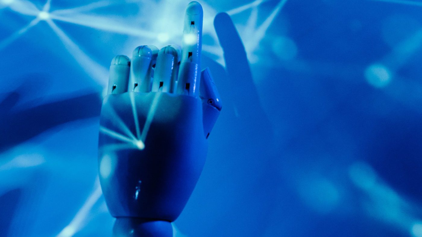 A robotic hand reaching toward a glowing digital neural network