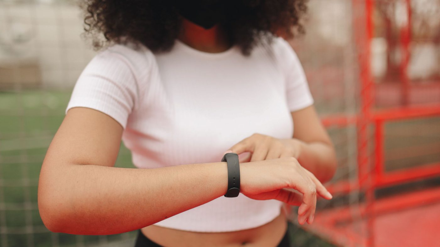 A person checking a fitness tracker band on their wrist